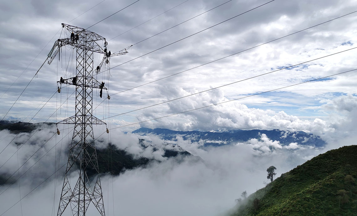 Mountain top, cloudy sky and electricity tower.