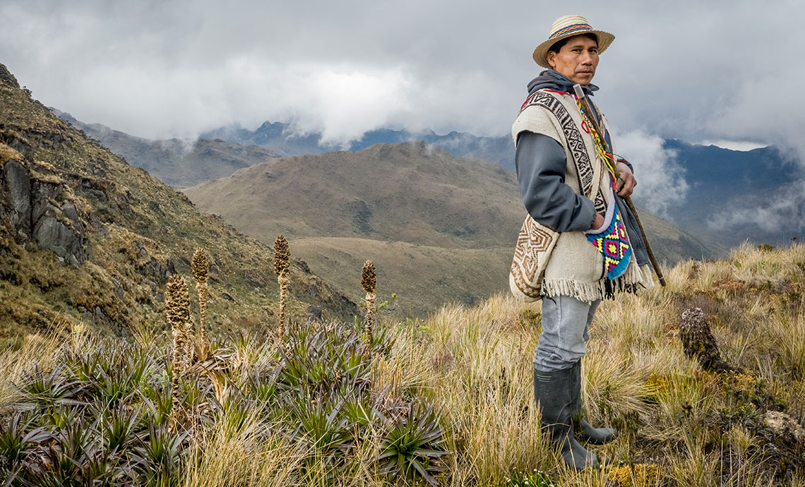 Photo of peasant wearing his ruana, work boots and hat at the páramo.