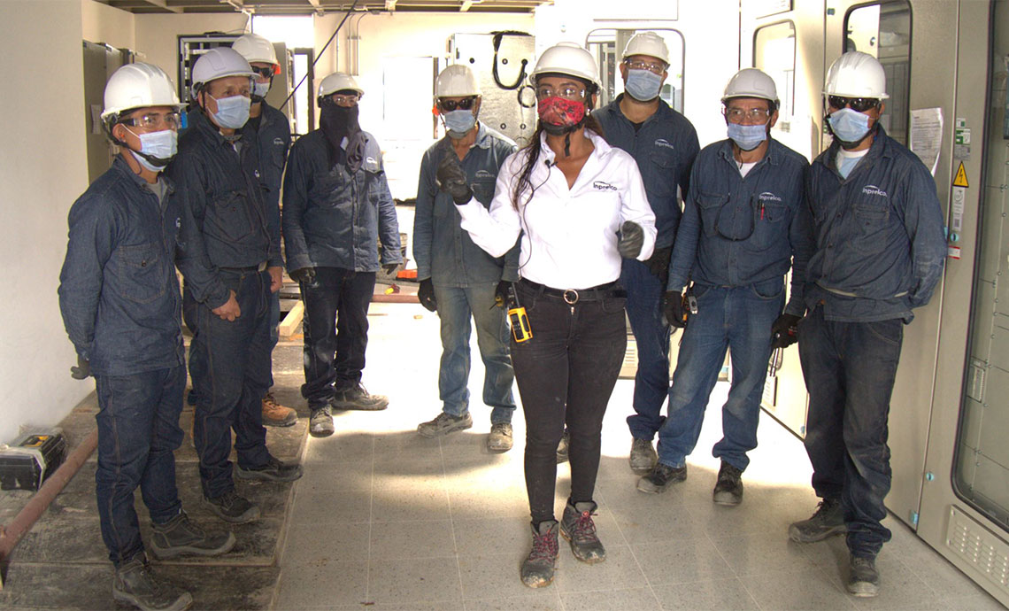 Woman leads a group of men at the Renacer Substation. 