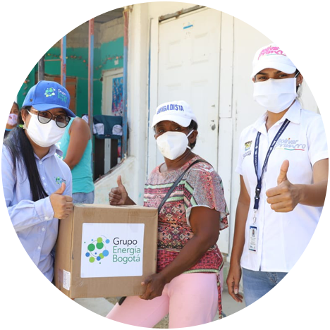 Three women wearing face masks with thumbs up hold a box labeled with the name GEB.